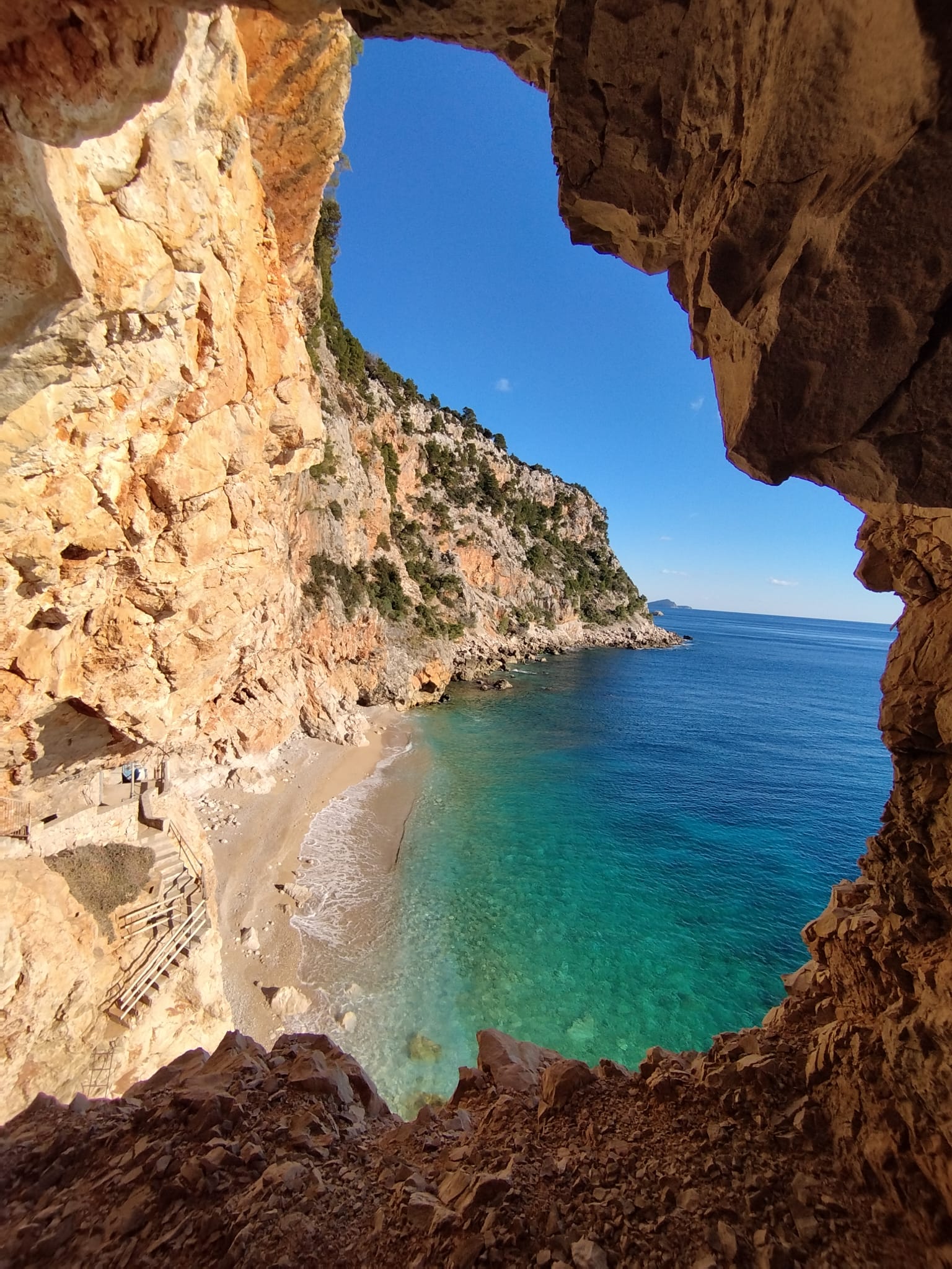 Pasjača beach in Konavle seen through a rock arch, with turquoise sea below steep cliffs