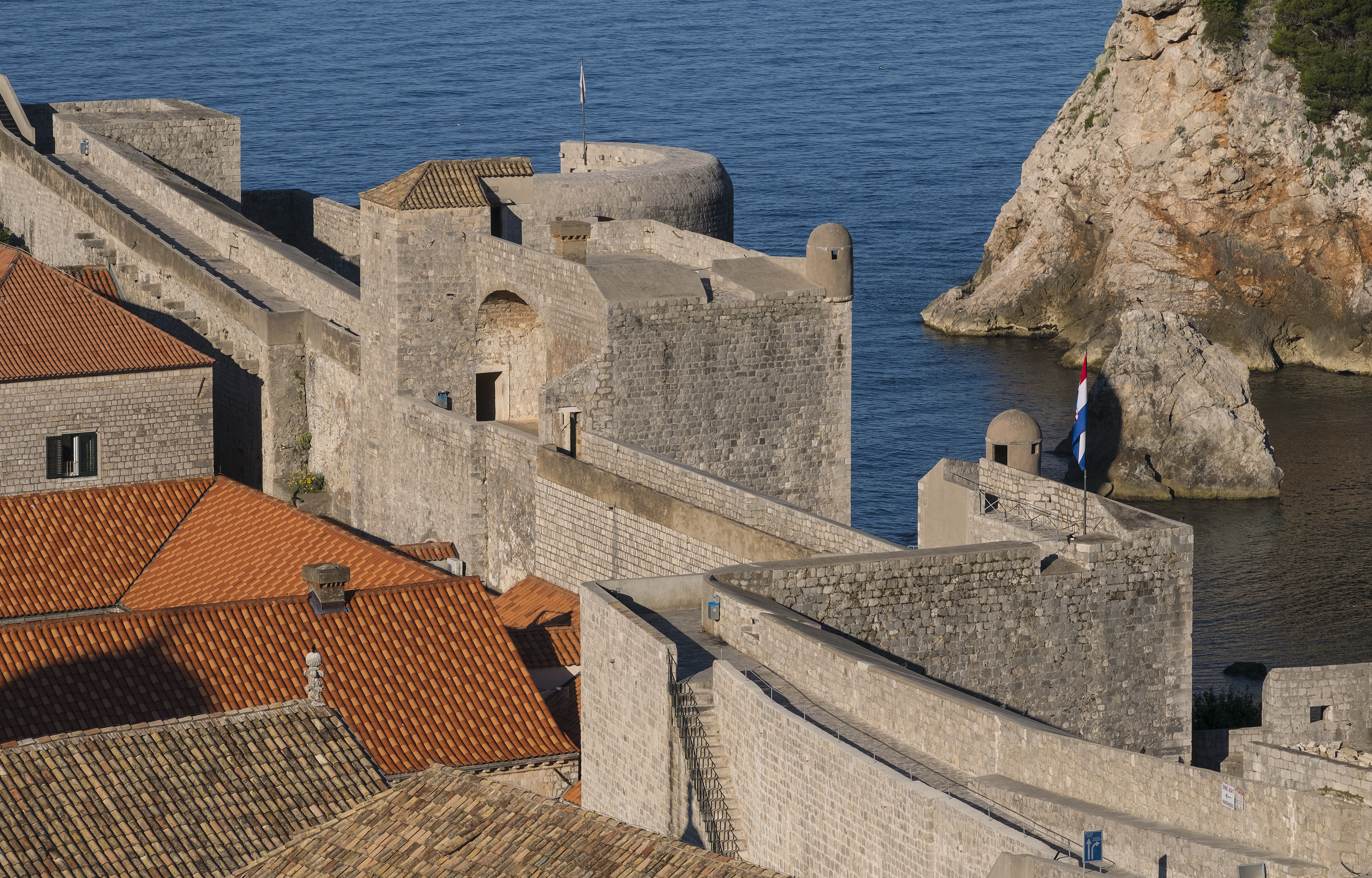 Dubrovnik City Walls and a fortress tower above red rooftops and the sea