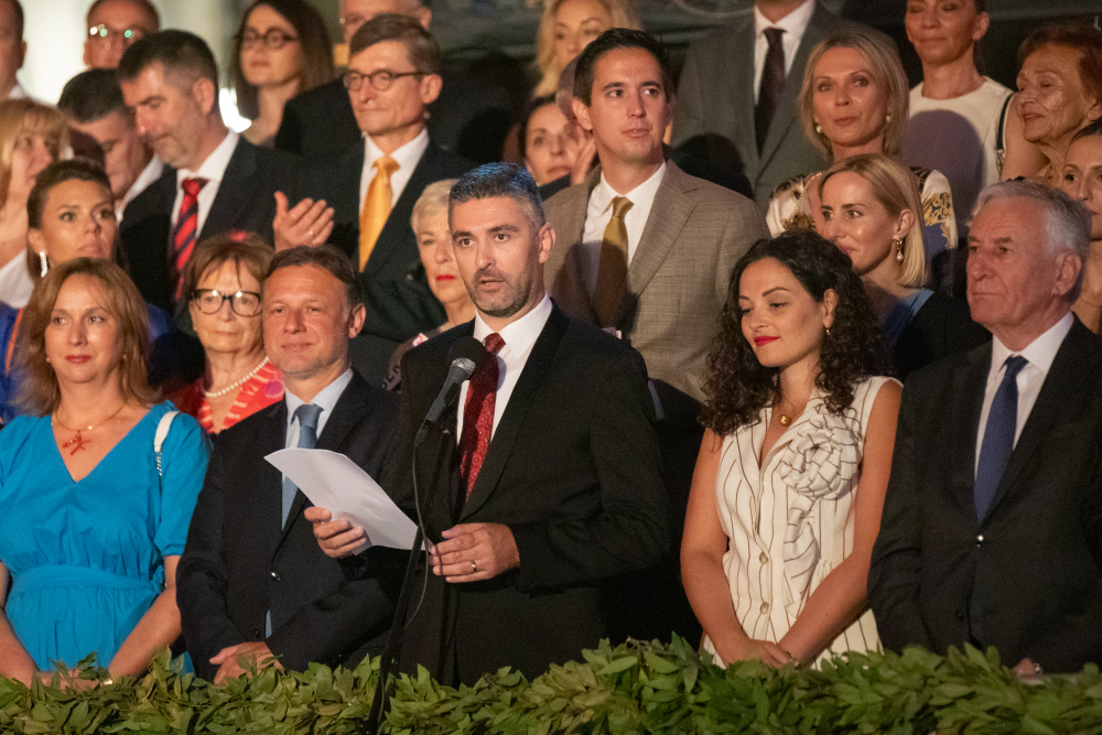 Speaker at a microphone with guests behind him at the opening of the 74th Dubrovnik Summer Festival