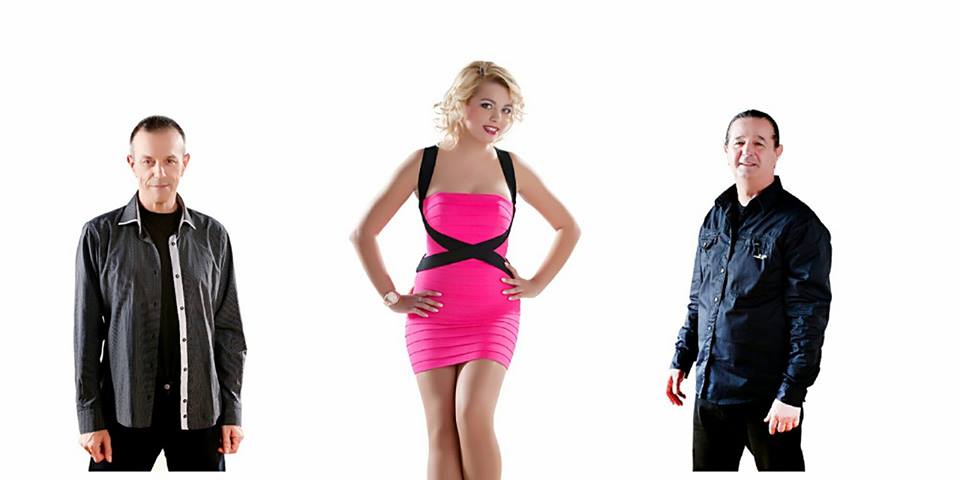 Promotional photo of a music trio, two men in dark shirts and a woman in a pink dress