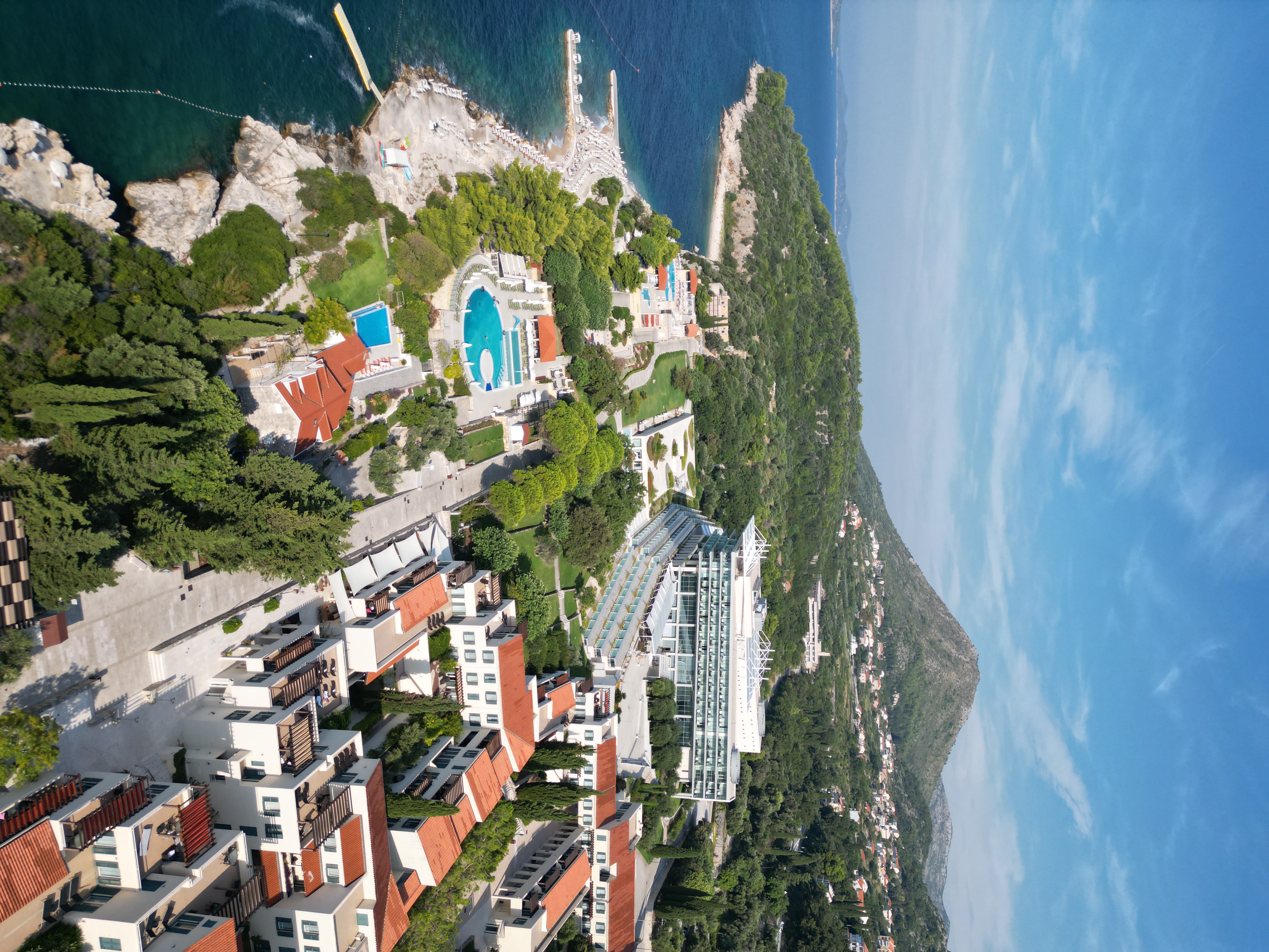 Aerial view of Dubrovnik Sea View Residences on the Orašac coast with pools, beach and hillside behind