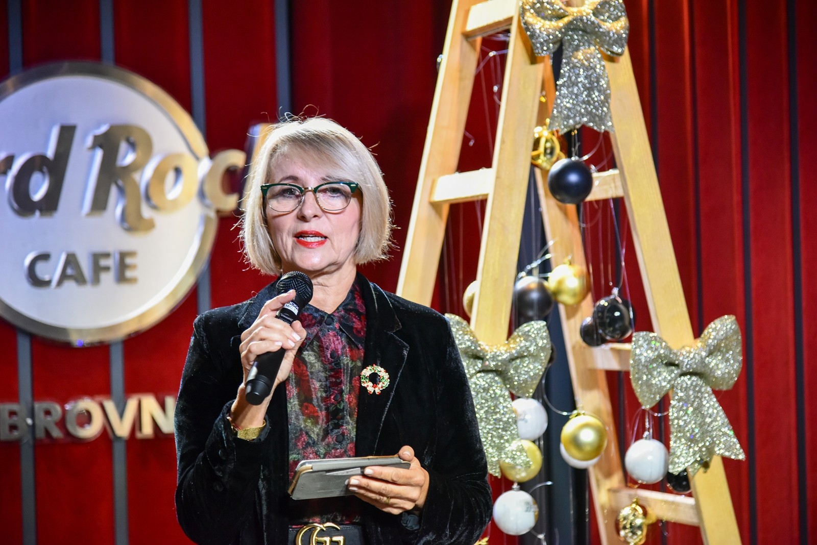 Woman speaking into a microphone at the Dubrovnik Winter Festival presentation at Hard Rock Cafe