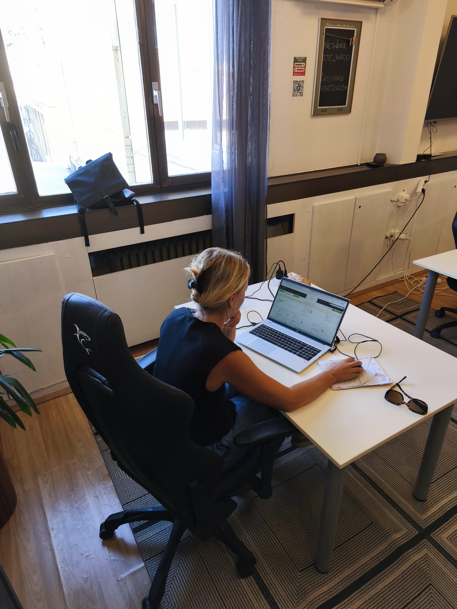 Remote worker on a laptop at a desk by the window in a bright co-working room in Dubrovnik
