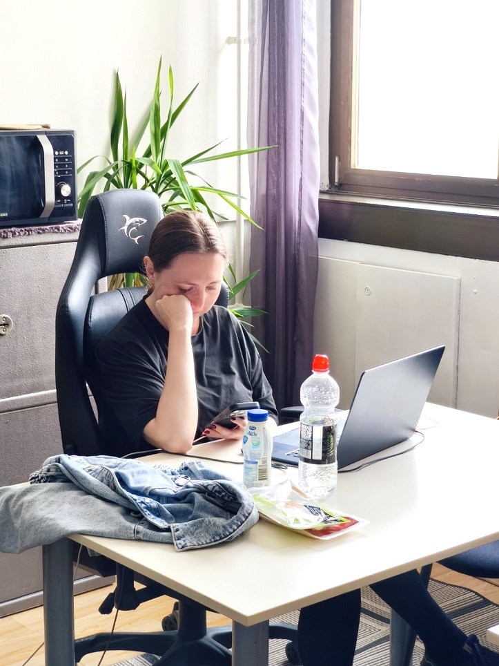 Digital nomad with a laptop resting her chin on her hand at a desk in the Gruž co-working space