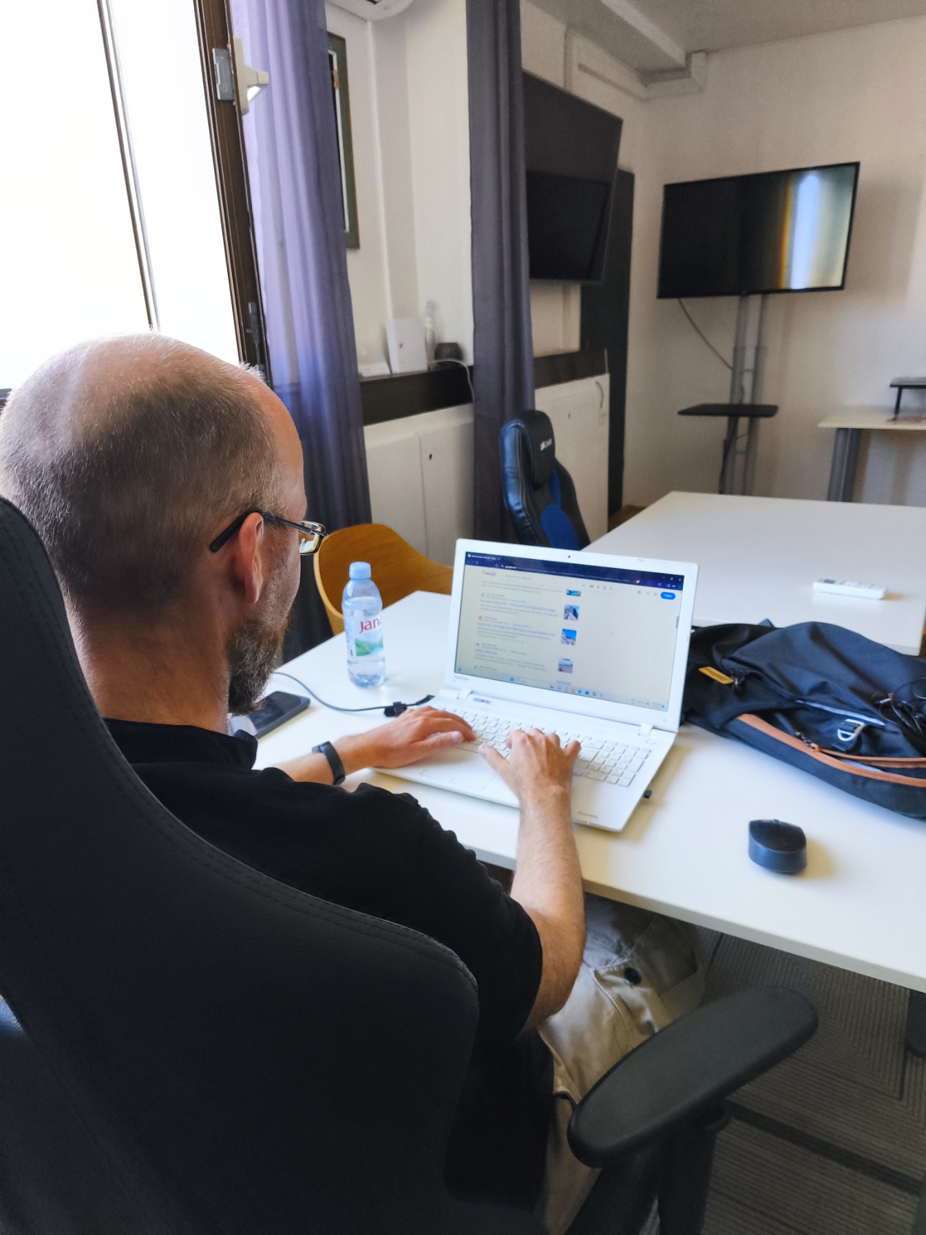 Remote worker typing on a laptop at a shared desk in Dubrovnik's free co-working space