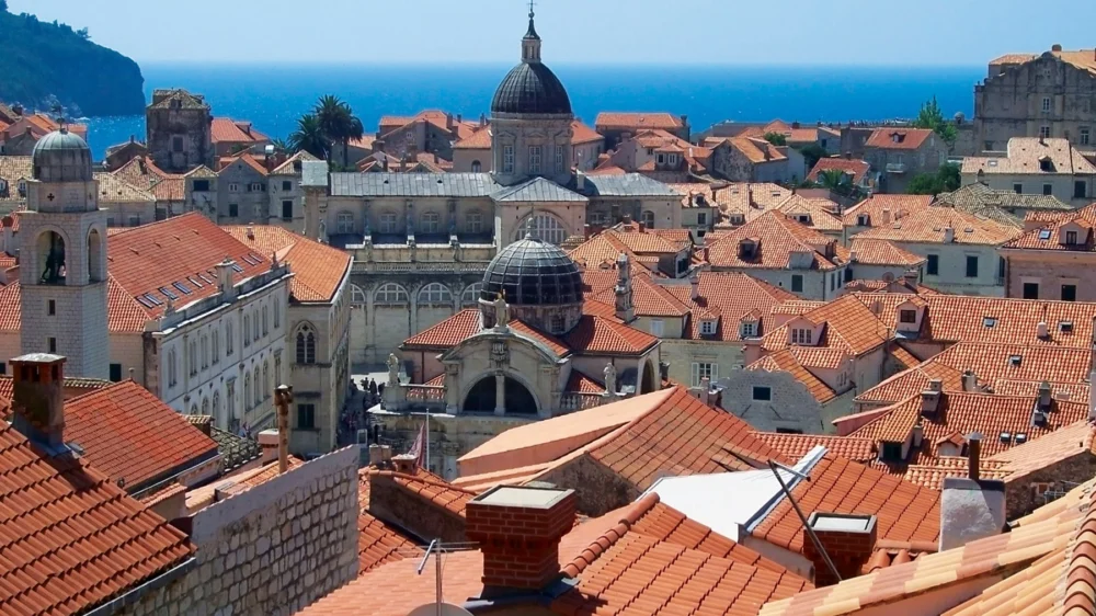 Red-tiled rooftops and church domes of Dubrovnik Old City with the Adriatic Sea behind
