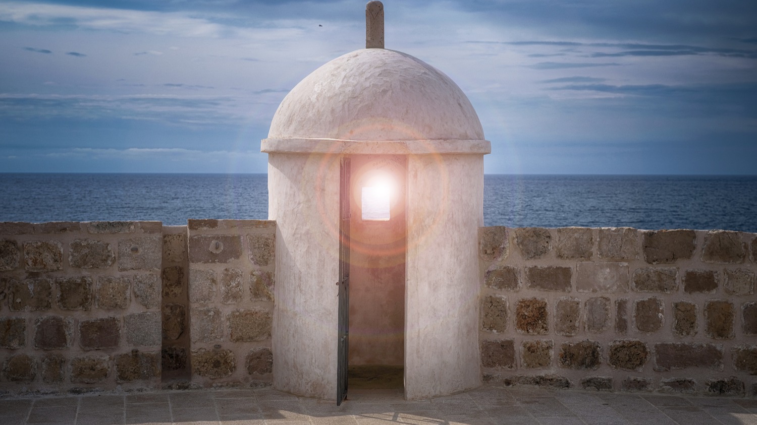 White domed sentry box on stone city walls overlooking the open sea